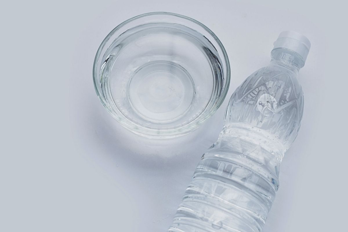 Frozen vinegar in a glass bowl and a  clear plastic bottle.