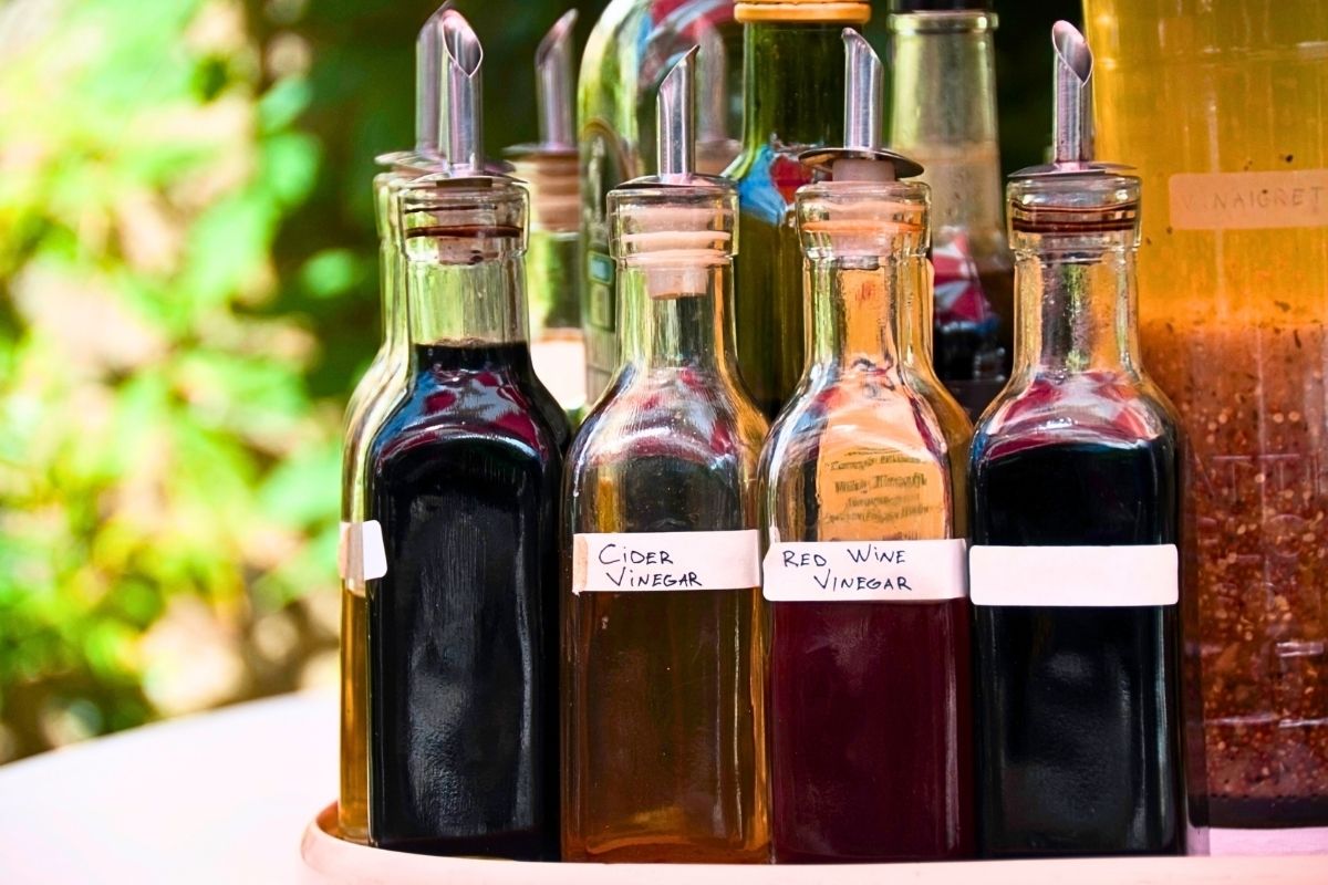 Rustic bottles of cooking vinegar in an outdoor setting.