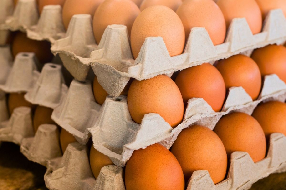 A stack of a crate of raw eggs.