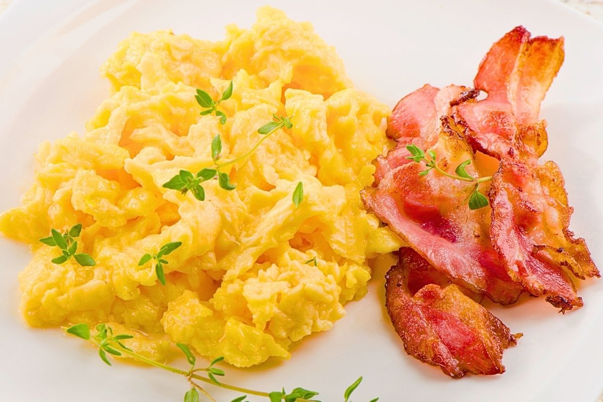 A close up of scrambled eggs and bacon