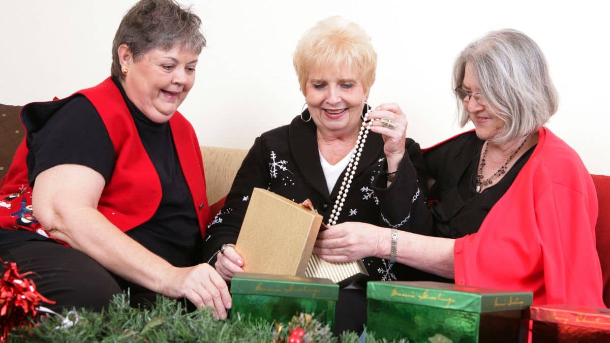 Three ladies unboxing Christmas gifts.