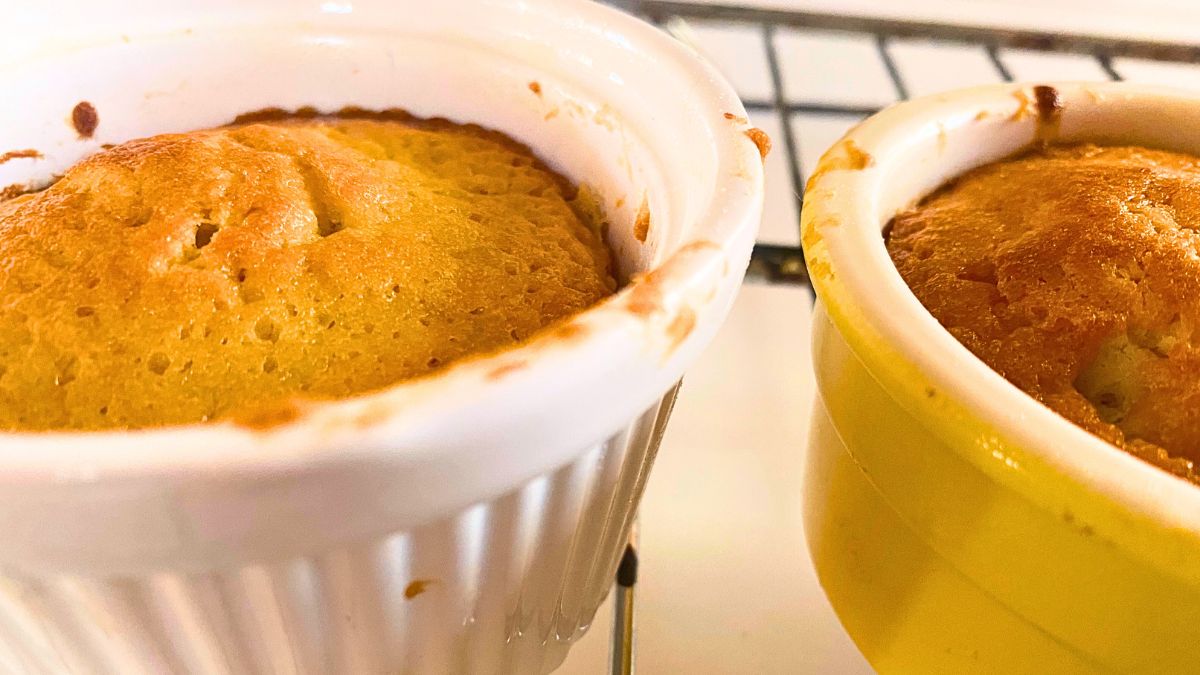 A close up of ramekin dishes with cake in them.
