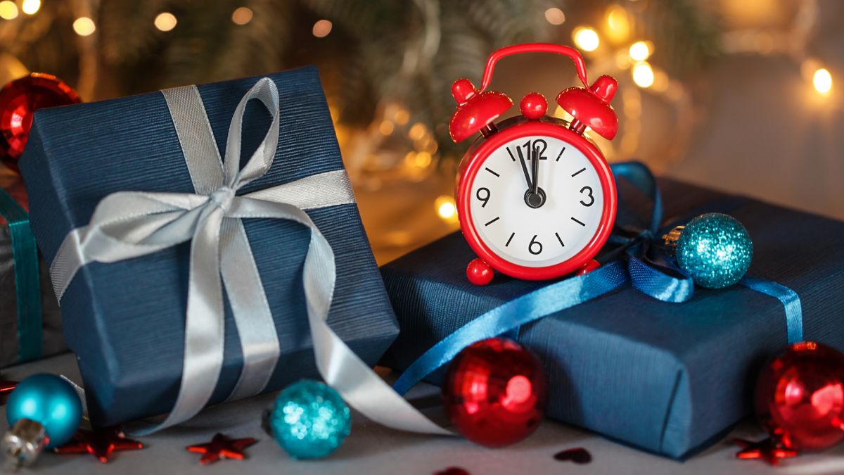 A red alarm clock on a blue gift boxes.
