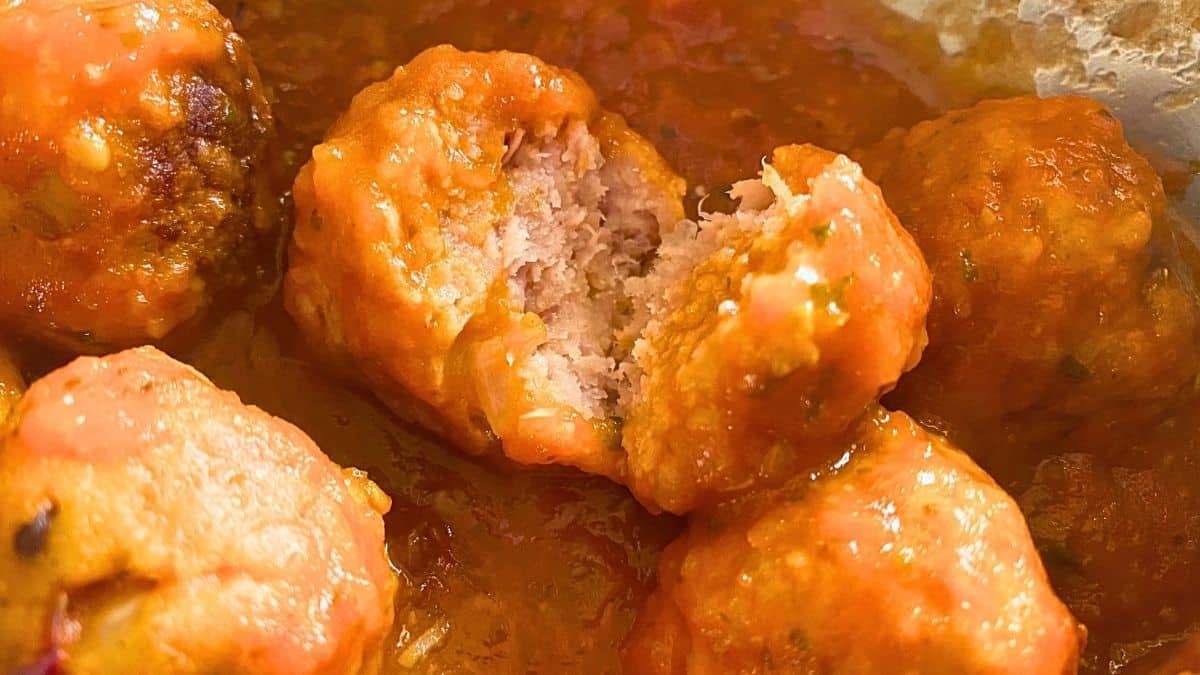 A close up of meatballs in marinara sauce.