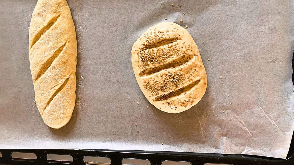 Two bread doughs on a baking tin.