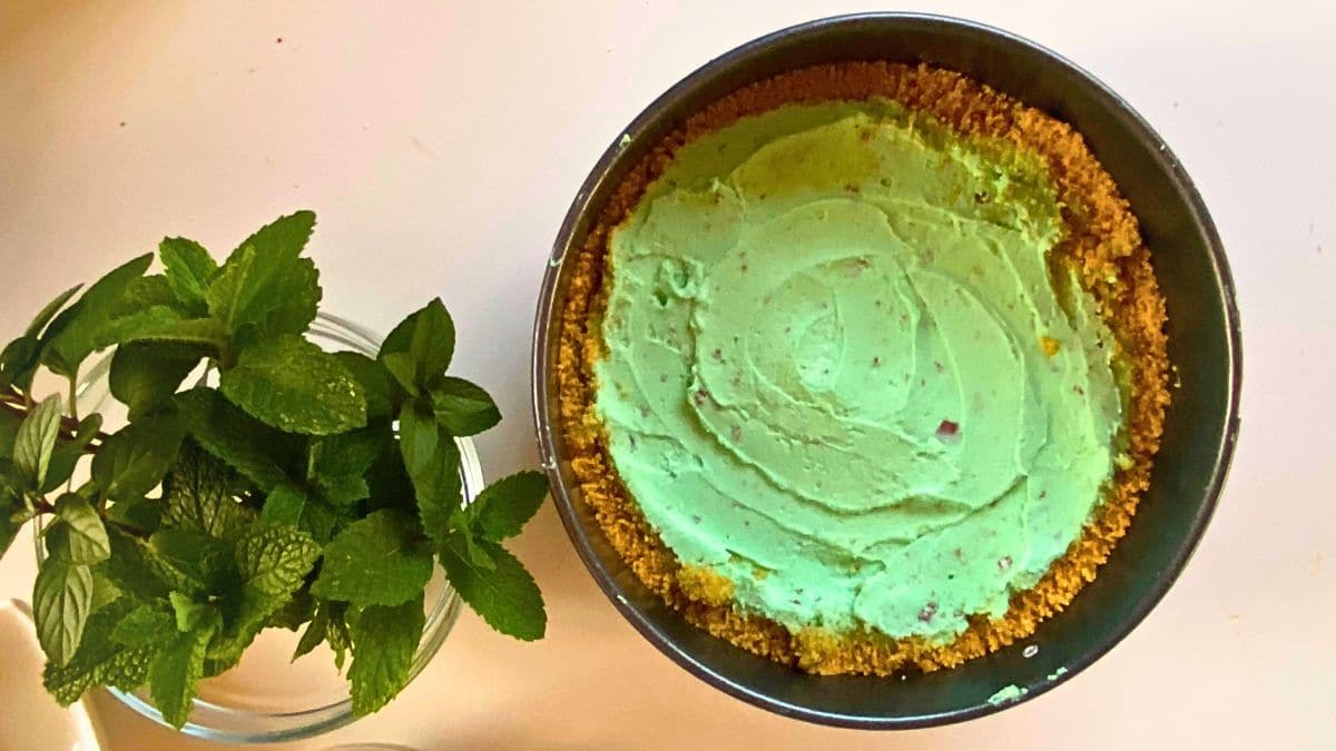 A cheese cake mixture in a bowl next to a bowl of mint.