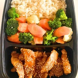 A black Meal Prep container with chicken and broccoli in it.