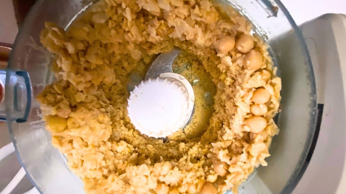 Chickpeas being mashed in a food processor.