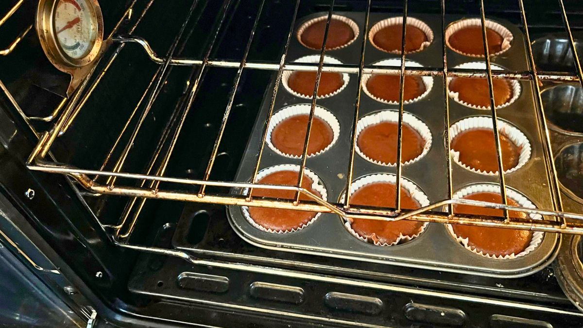 A tray of cupcakes in an oven.