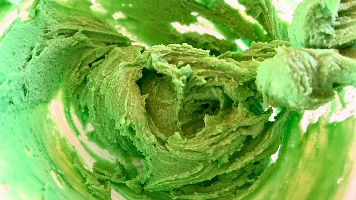 Green cake frosting in a mixing bowl.
