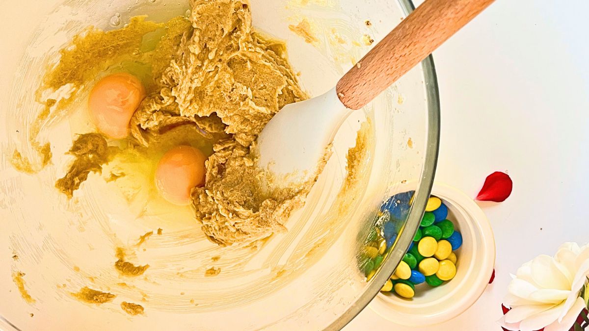 A bowl of cookie mix with egg yolks in it.