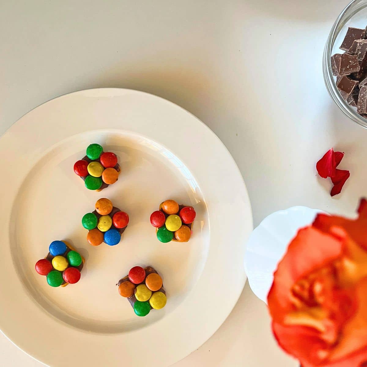 A plate of Easter chocolate with M and M flowers on a table.