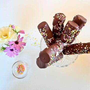 Chocolate covered chocolate bars with sprinkles on top of a glass dish.